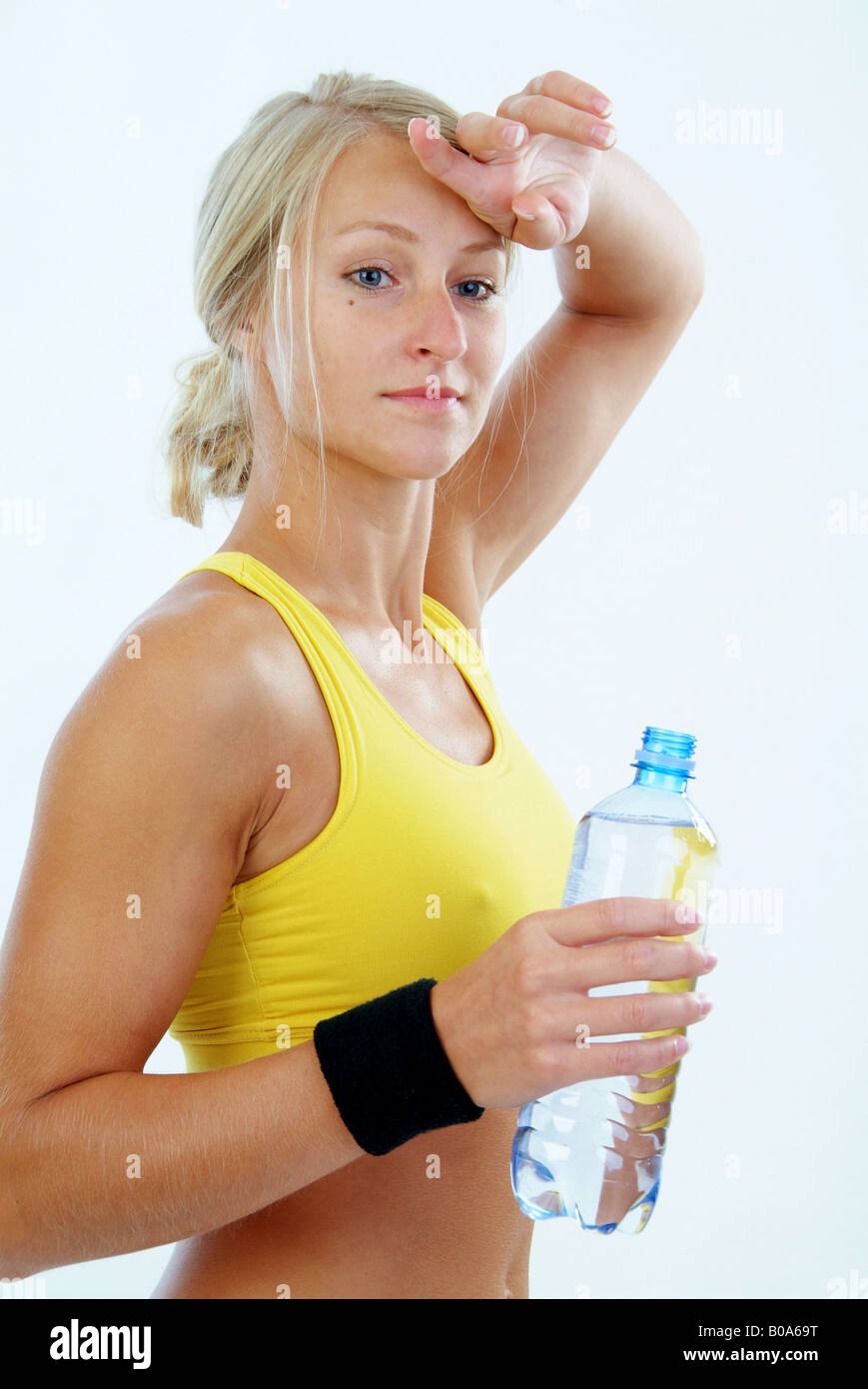 Usurati donna bionda con acqua in bottiglia dopo il corso di formazione Foto Stock