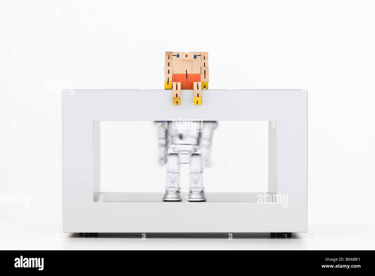 Robot di legno guardando giù al robot metallico sotto scuotimento Foto Stock