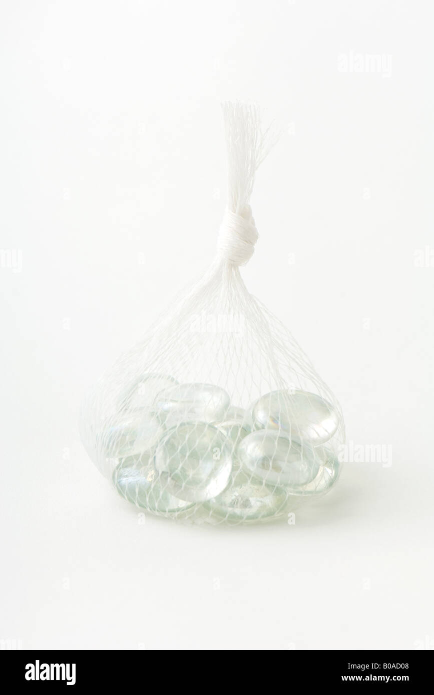 Granelli di vetro in borsa a rete, close-up Foto Stock