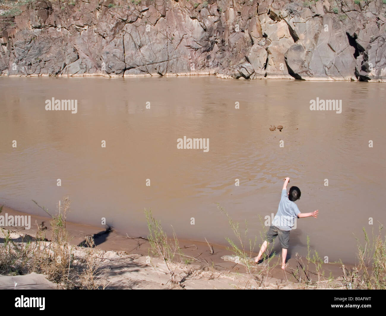 Ragazzo di lanci di fango nel fango del Fiume Colorado Foto Stock