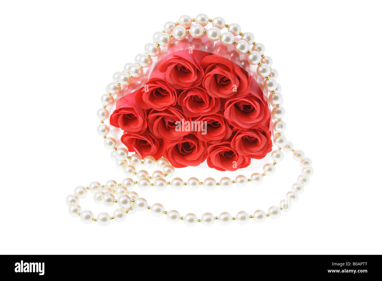 Collana di perle intorno rose rosse Foto Stock