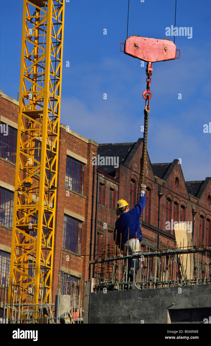 Operaio edile di guida del carico della gru e il paranco sul sito di costruzione in Leeds Yorkshire Regno Unito Foto Stock