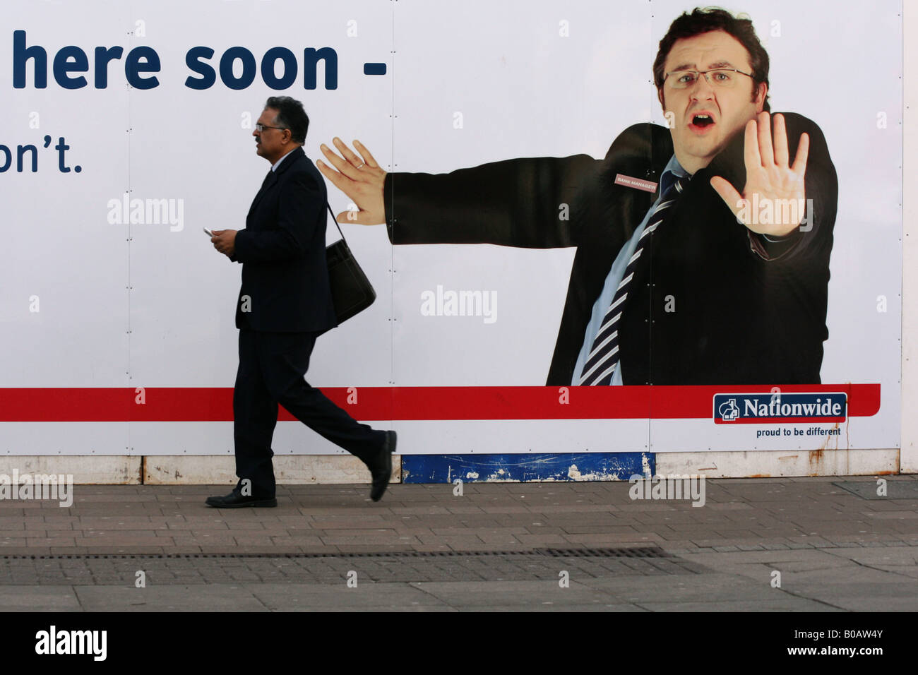 Uomo di affari passato a piedi una banca nazionale poster pubblicitario nel Regno Unito. fotografia DON TONGE Foto Stock