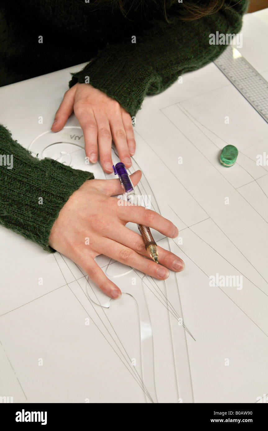Giovane donna disegna una curva utilizzando un righello francese curva in altuglass, vetro acrilico. Foto Stock