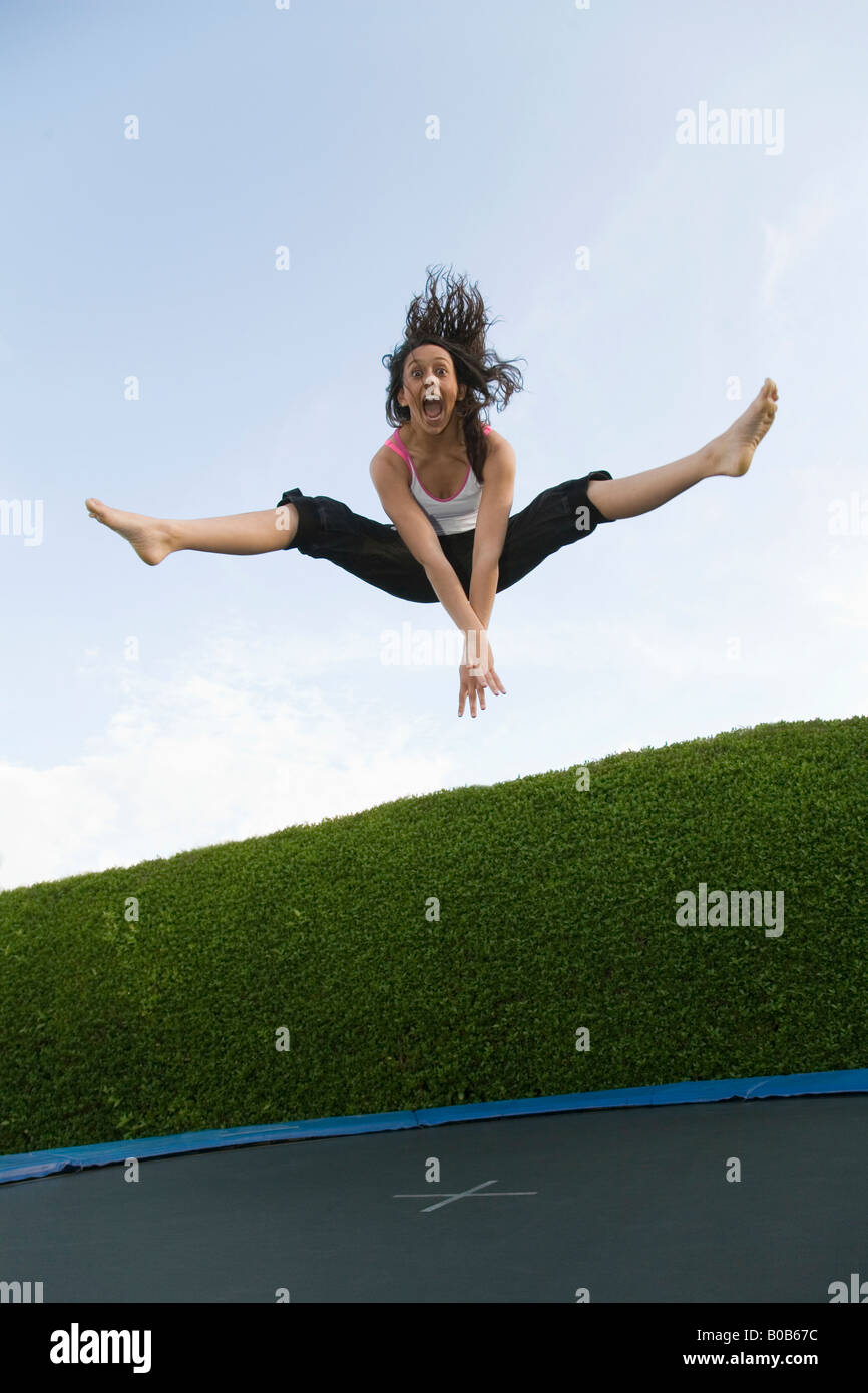 Giovane donna trampolino; una ragazza adolescente età 16 anni dumping su un trampolino, REGNO UNITO Foto Stock