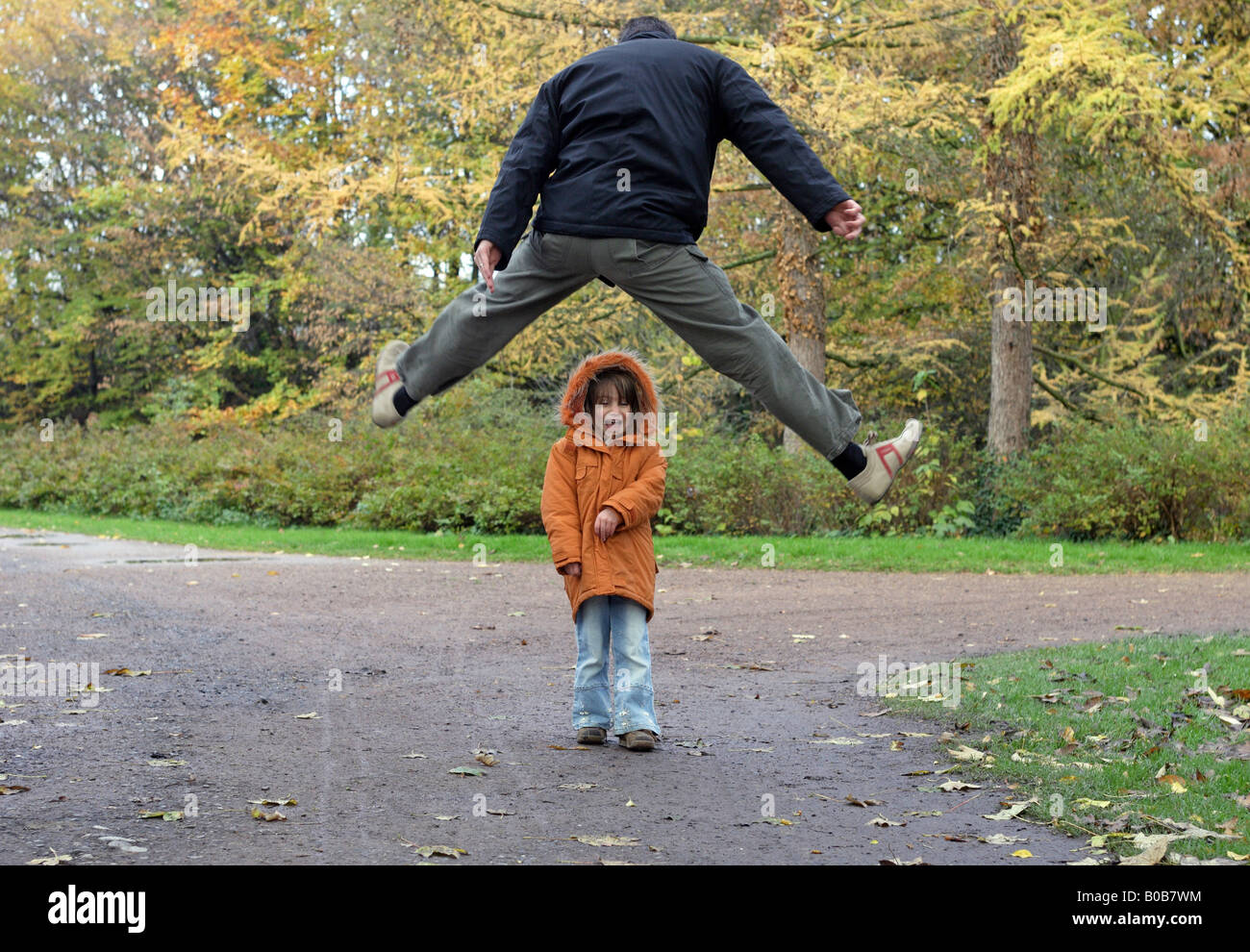 L'uomo saltando su un bambino in un parco Foto Stock