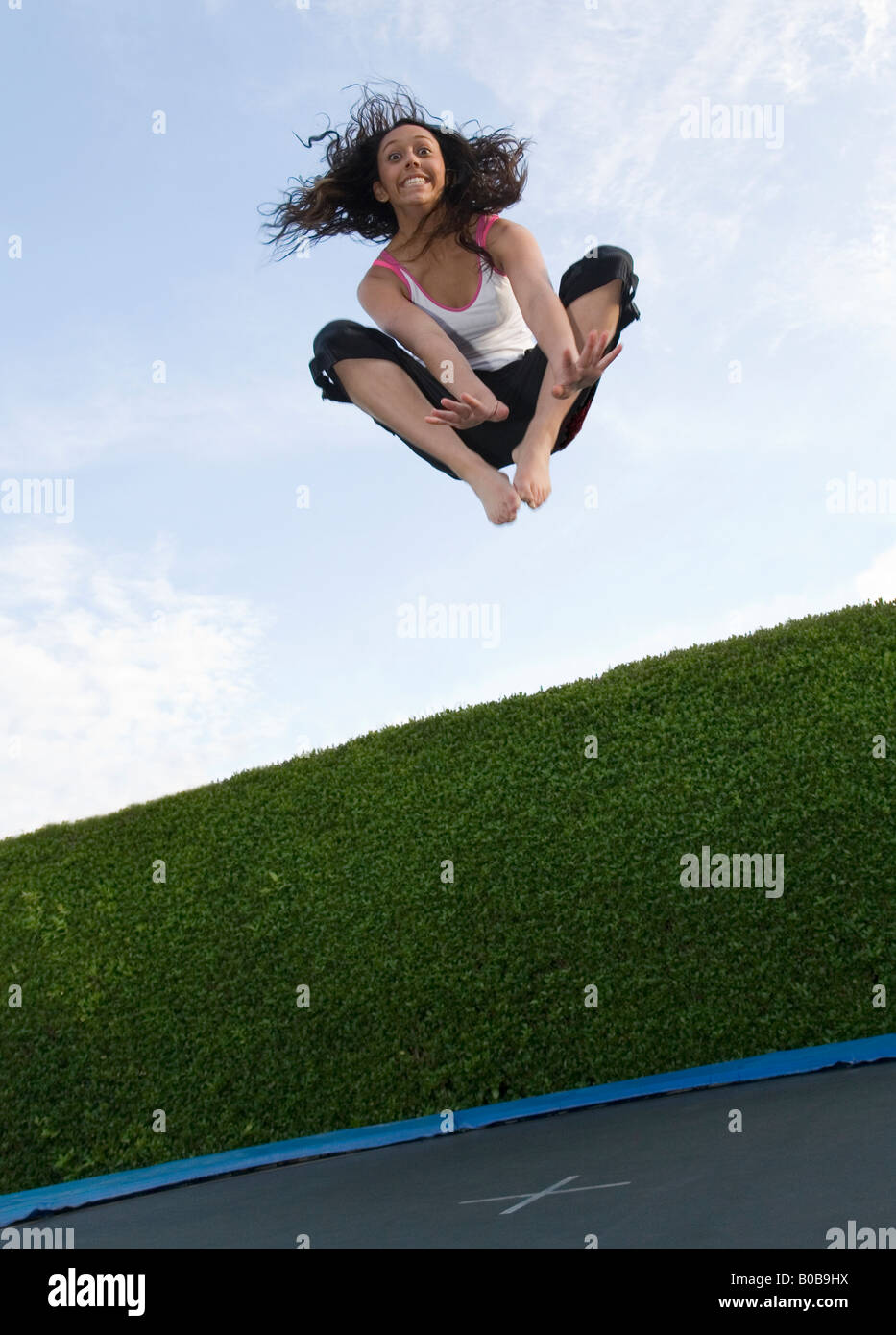Un adolescente ragazza adolescente età 16 anni saltando su un trampolino, REGNO UNITO Foto Stock