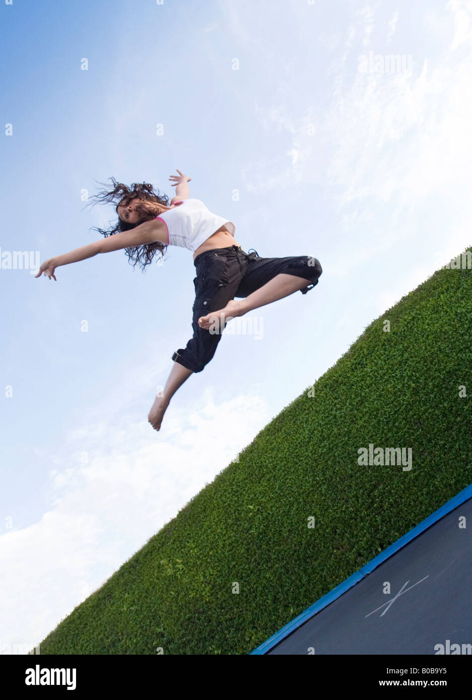 Un felice giovane donna saltando su un trampolino, REGNO UNITO Foto Stock