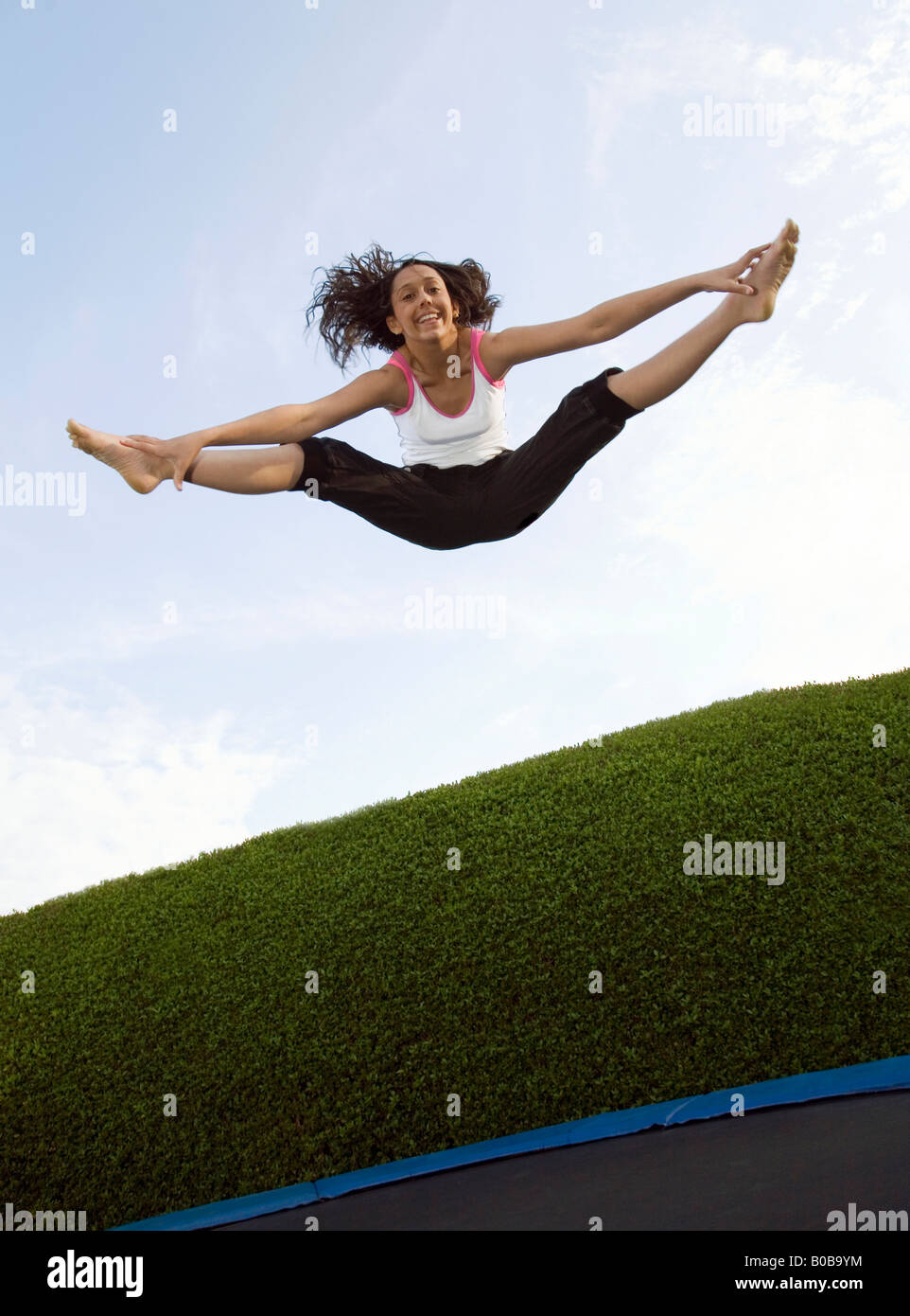 Una giovane donna saltando su un trampolino, REGNO UNITO Foto Stock