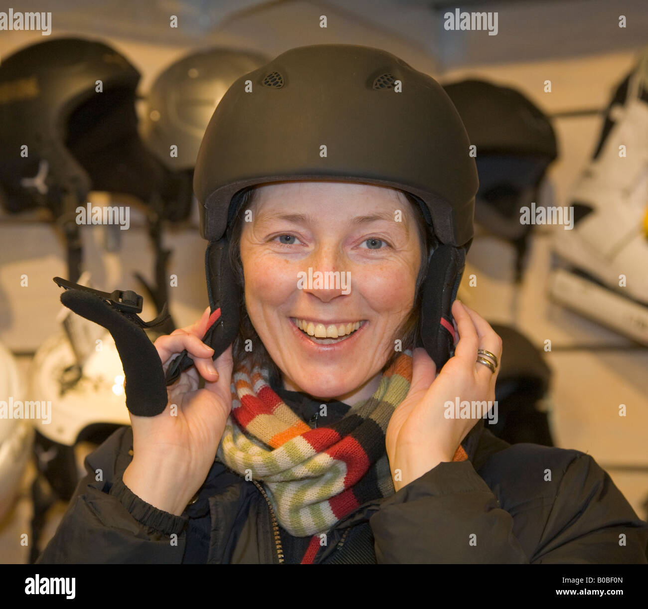 A quarant'anni vecchia donna shopping per un casco da sci in un negozio di articoli sportivi a Kiruna / Svezia settentrionale Foto Stock