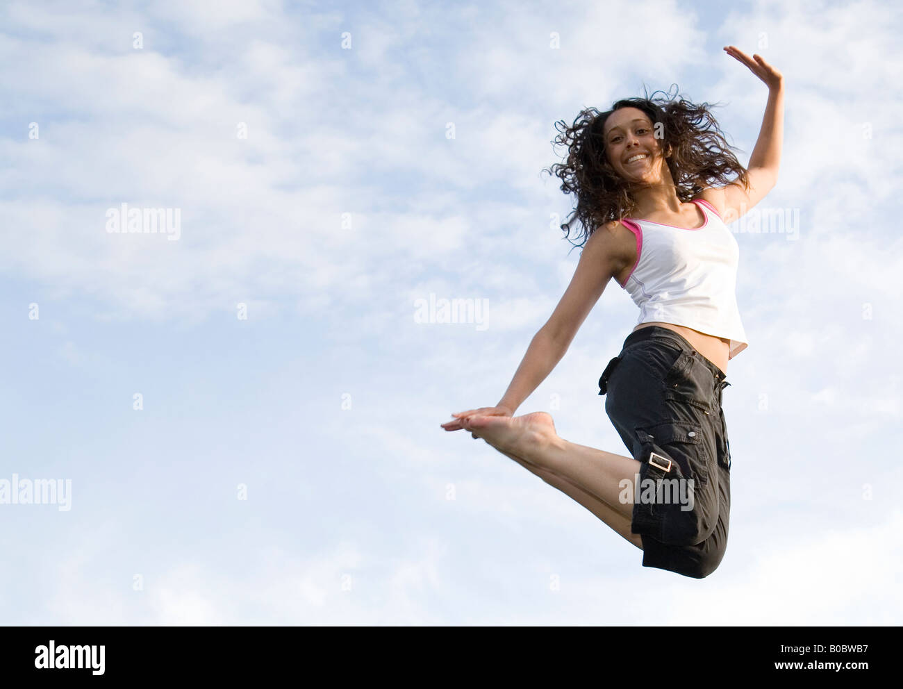 Una giovane donna di saltare in aria su un trampolino e trampolining, REGNO UNITO Foto Stock