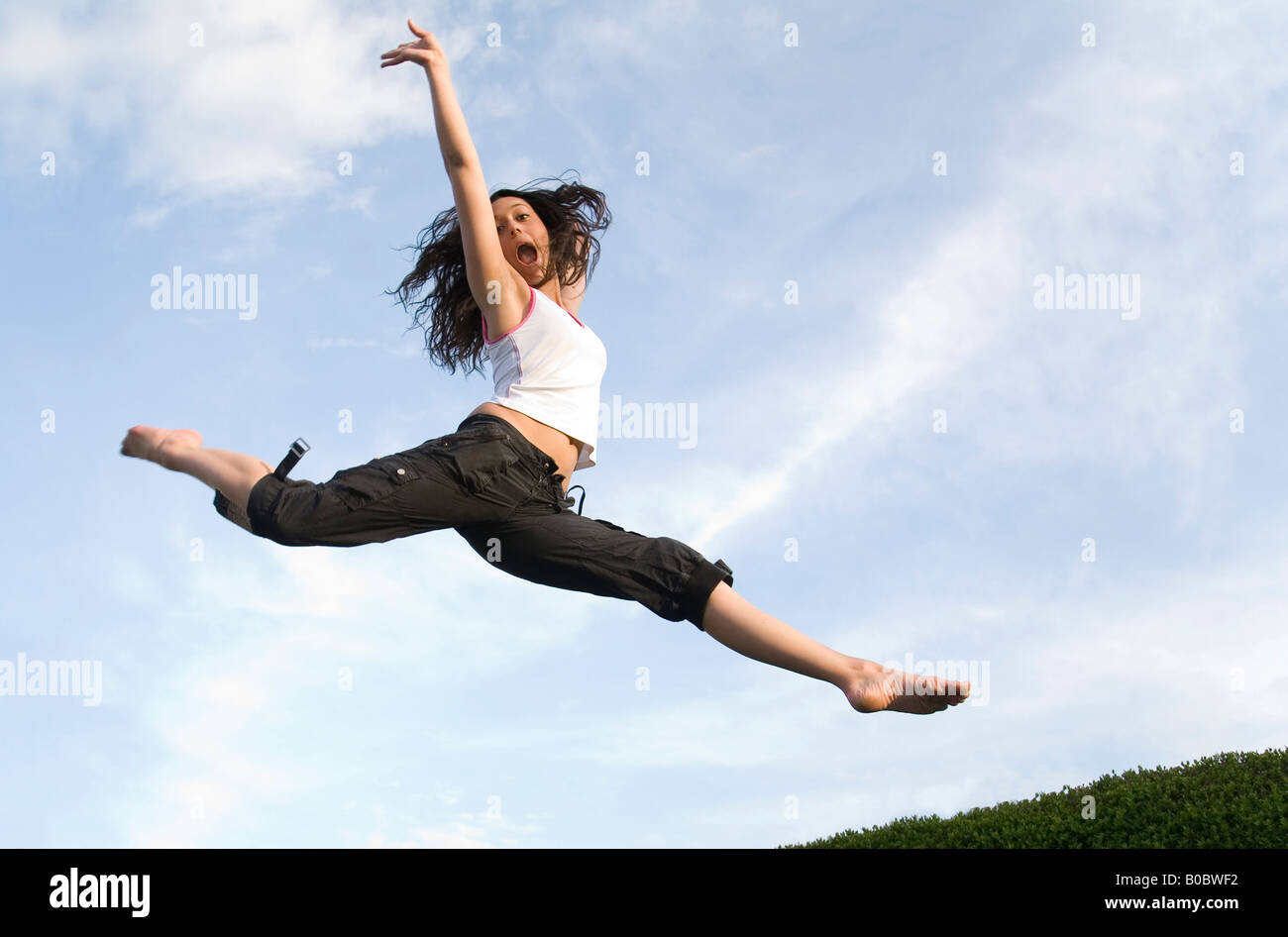 Una ragazza adolescente saltando su un trampolino Foto Stock