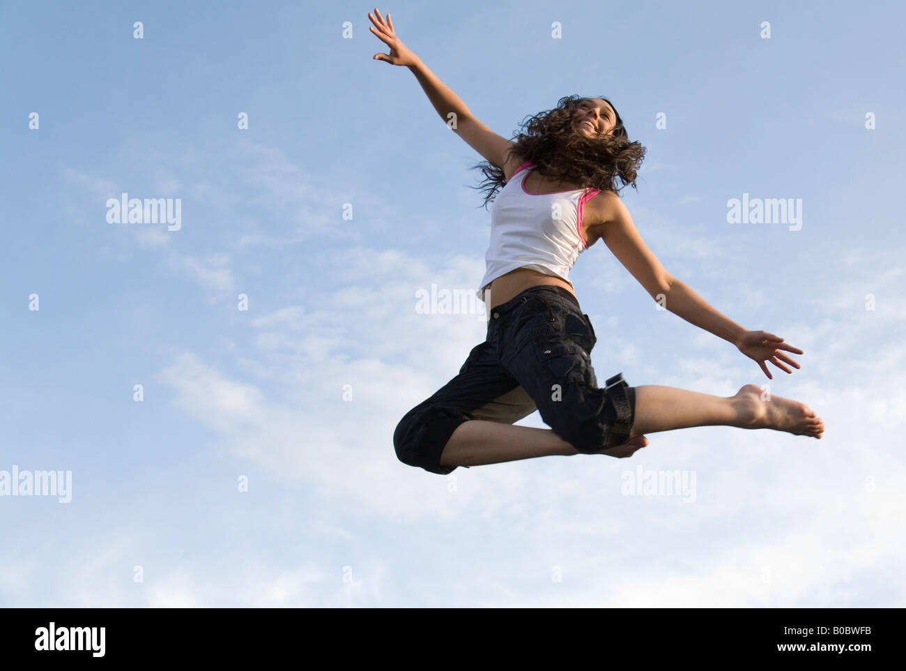 Una ragazza adolescente saltando su un trampolino Foto Stock