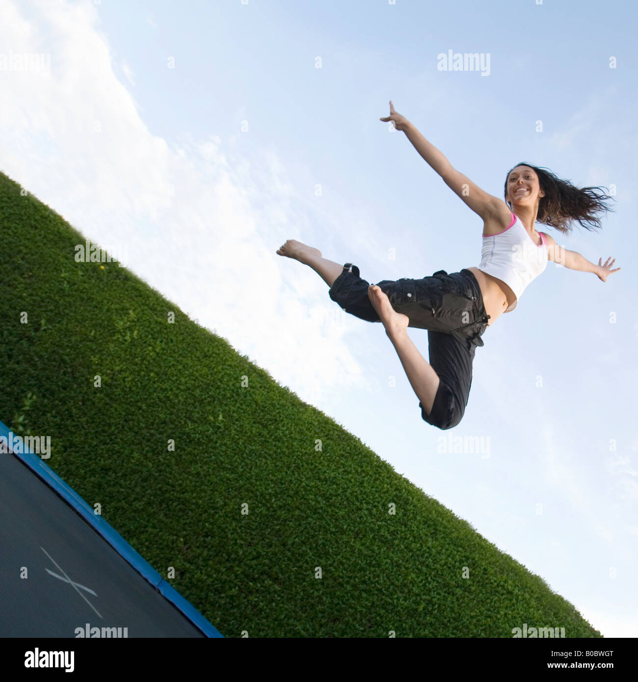 Una ragazza adolescente saltando su un trampolino, REGNO UNITO Foto Stock