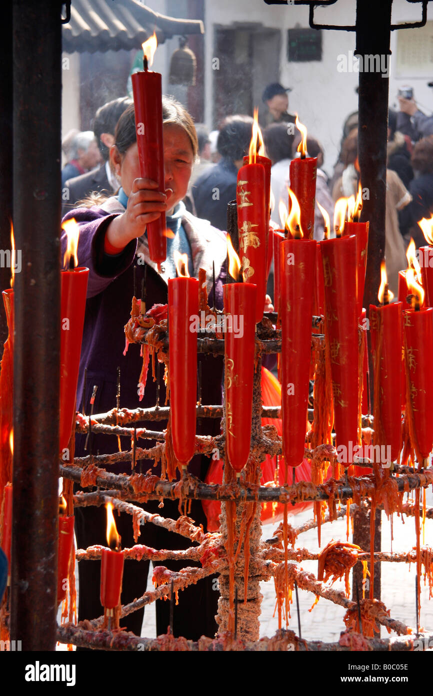 Un buddista cinese donna accendendo candele alla Hanshan o freddo tempio di montagna vicino a Suzhou.La Cina. Foto Stock