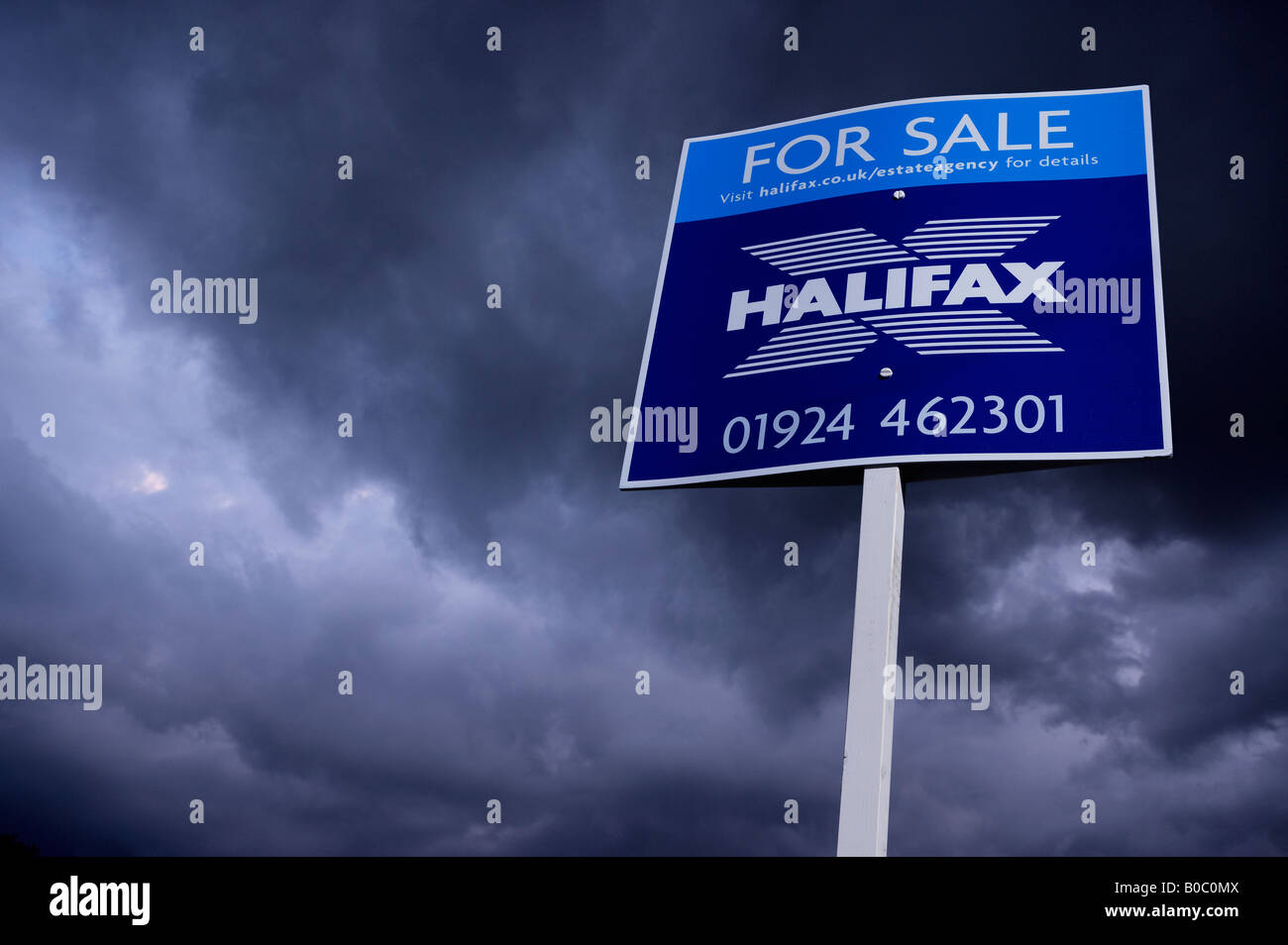 Agente immobiliare CASA IN VENDITA segno con cielo tempestoso Foto Stock
