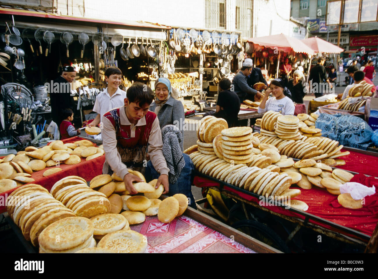 Uiguri vendita di pane naan nel mercato sulla minoranza di Xinjiang Street di Urumqi, Xinjiang, Cina Foto Stock