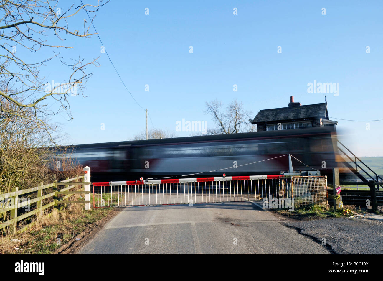 Il treno sulla barriera incrocio ferroviario, North Yorkshire, Inghilterra Foto Stock
