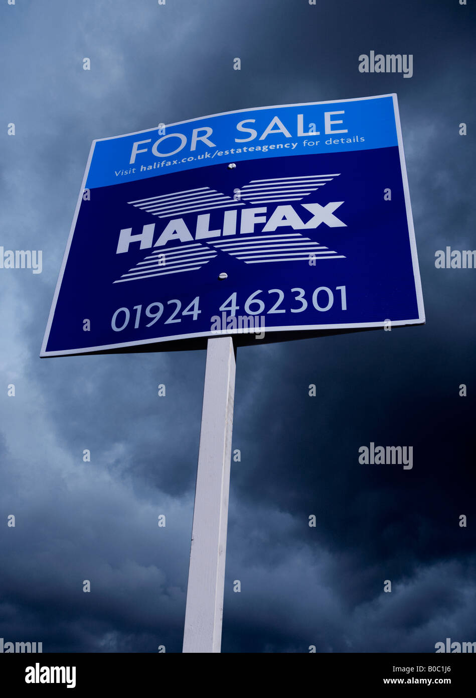 Agente immobiliare CASA IN VENDITA segno con cielo tempestoso Foto Stock