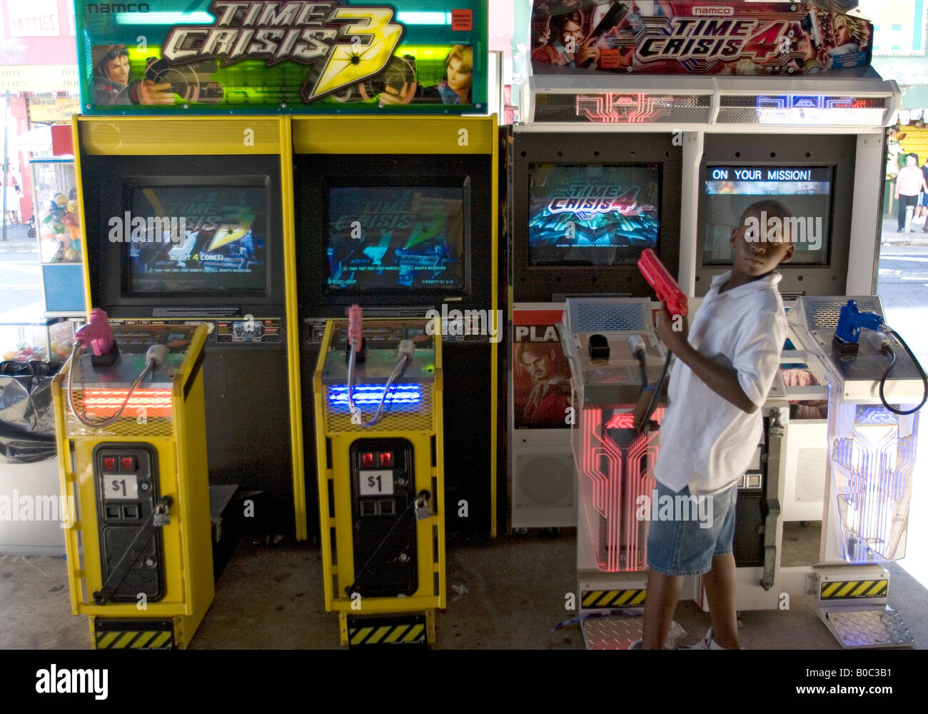 African American Boy con un video gioco arcade di pistola in mano a Coney Island, Brooklyn, NY Foto Stock