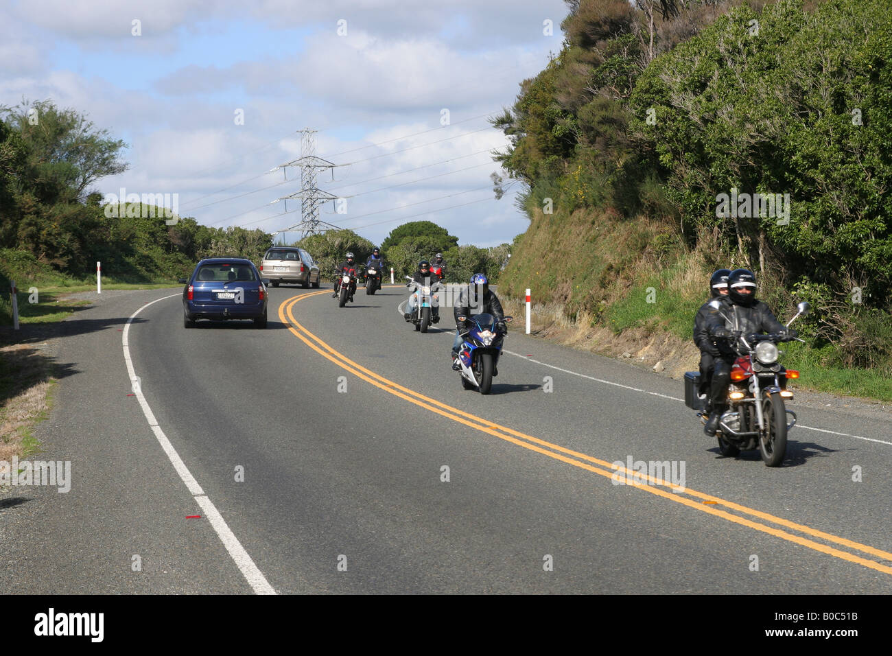 Motocicli e Autoveicoli che viaggiano lungo una strada di campagna. Foto Stock