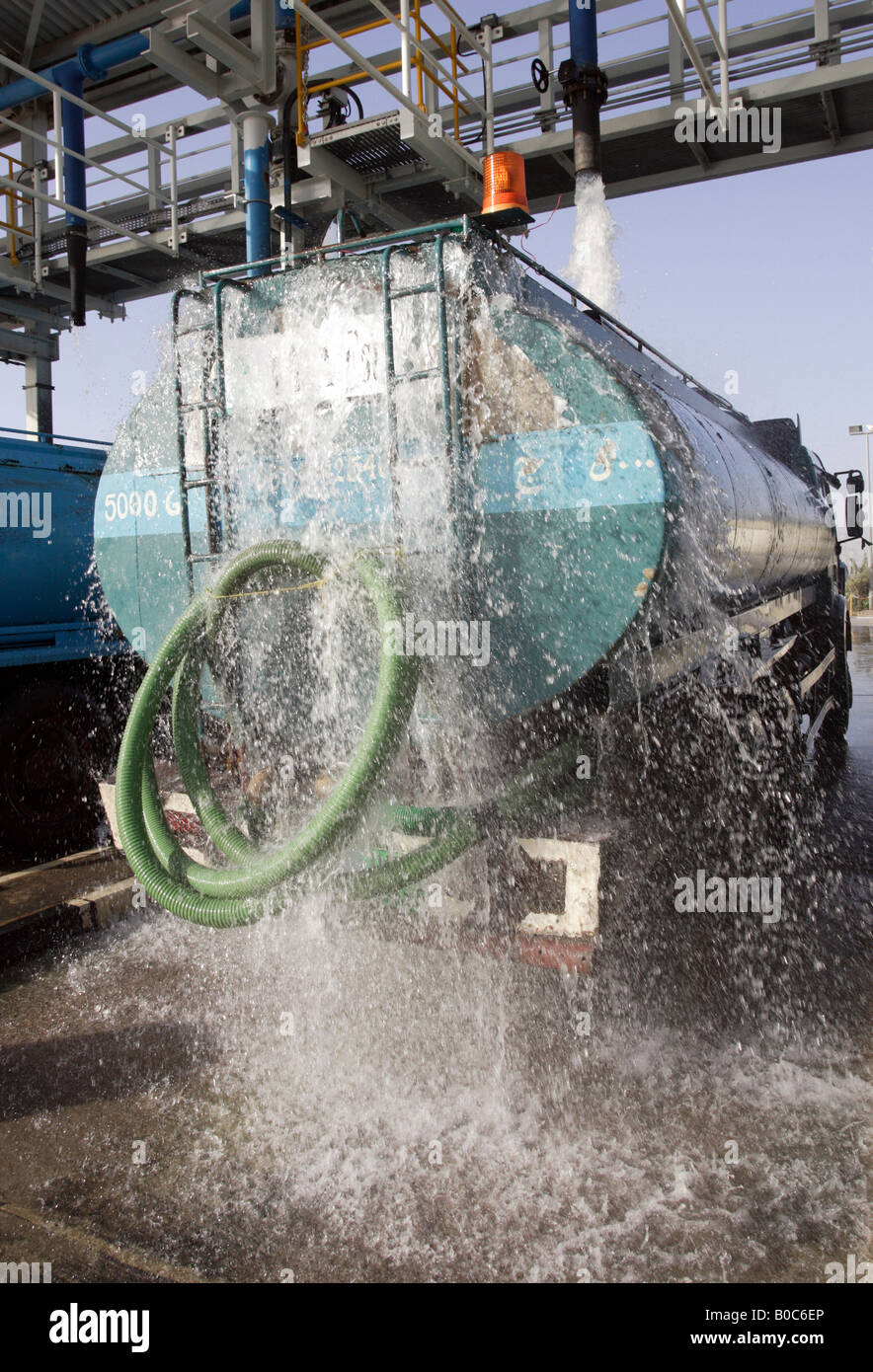 Un camion di acqua essendo caricato con acqua, Dubai, Emirati Arabi Uniti Foto Stock