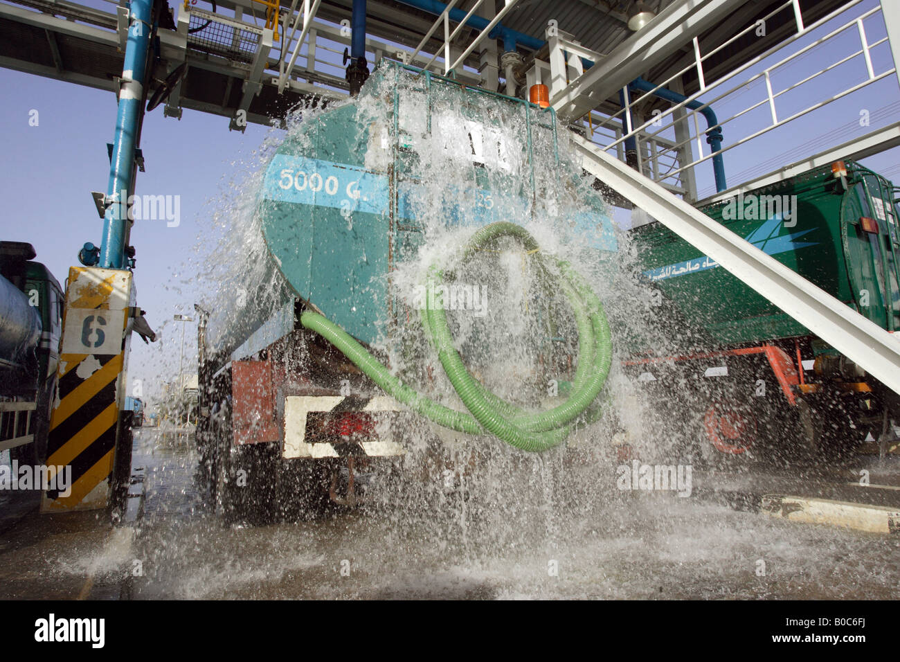Un camion di acqua essendo caricato con acqua, Dubai, Emirati Arabi Uniti Foto Stock