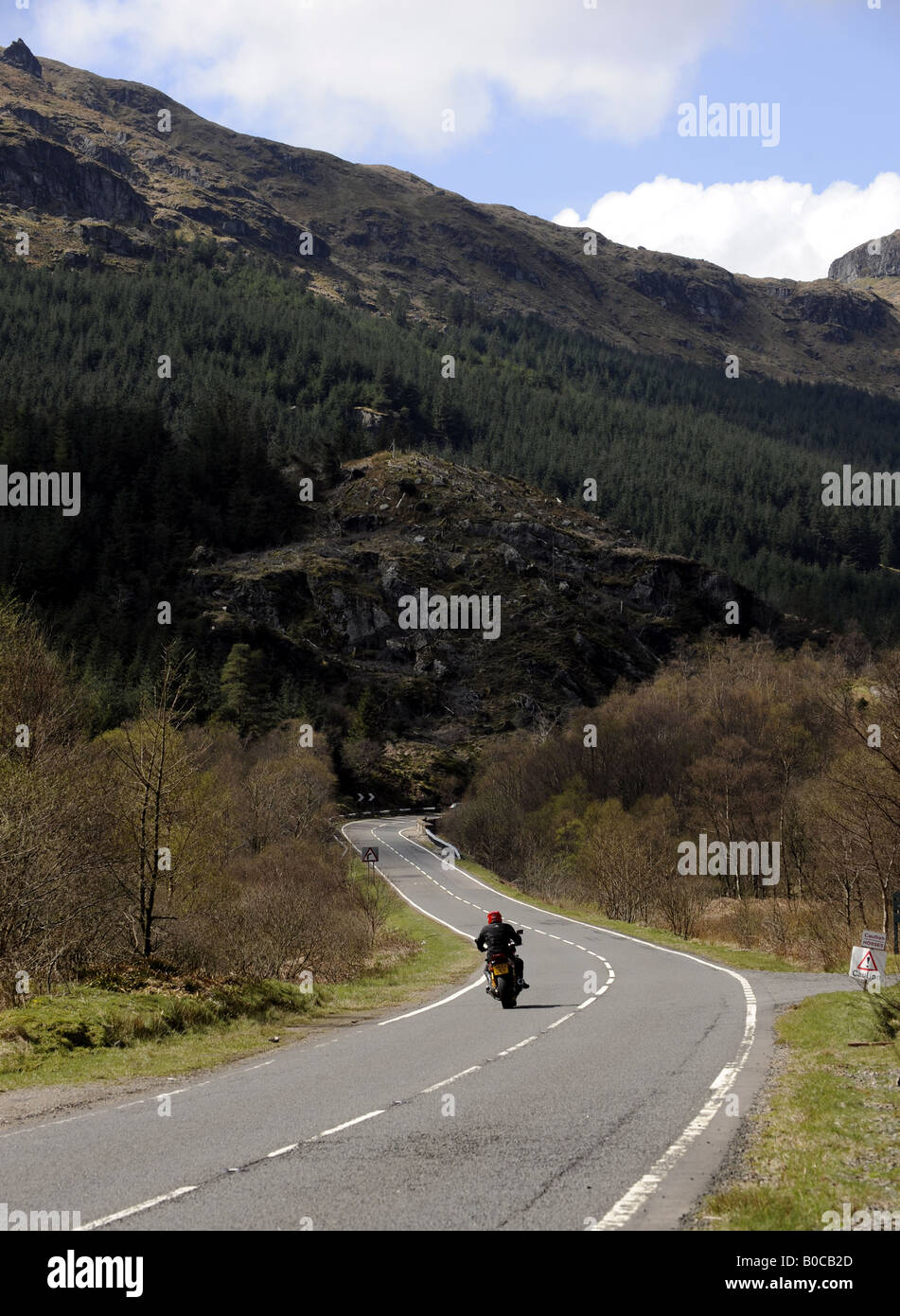 Un motociclista gode della libertà di strade nelle Highlands della Scozia,UK. Foto Stock