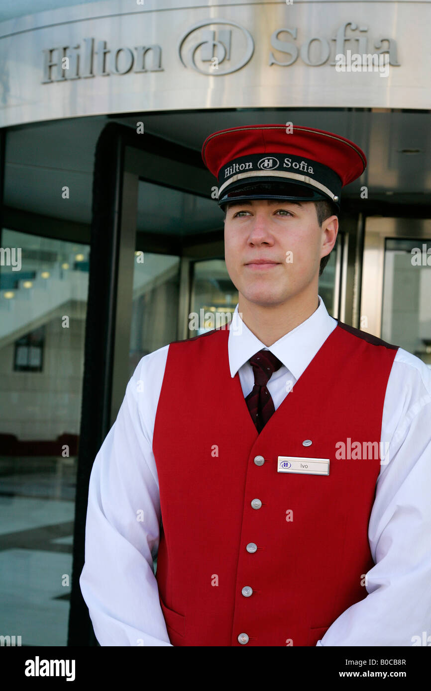 Commissionario stand sistemazione permanente bell hop uniforme il personale dell'hotel entrata dettaglio di lusso opulento ed elegante design del ragazzo o Foto Stock