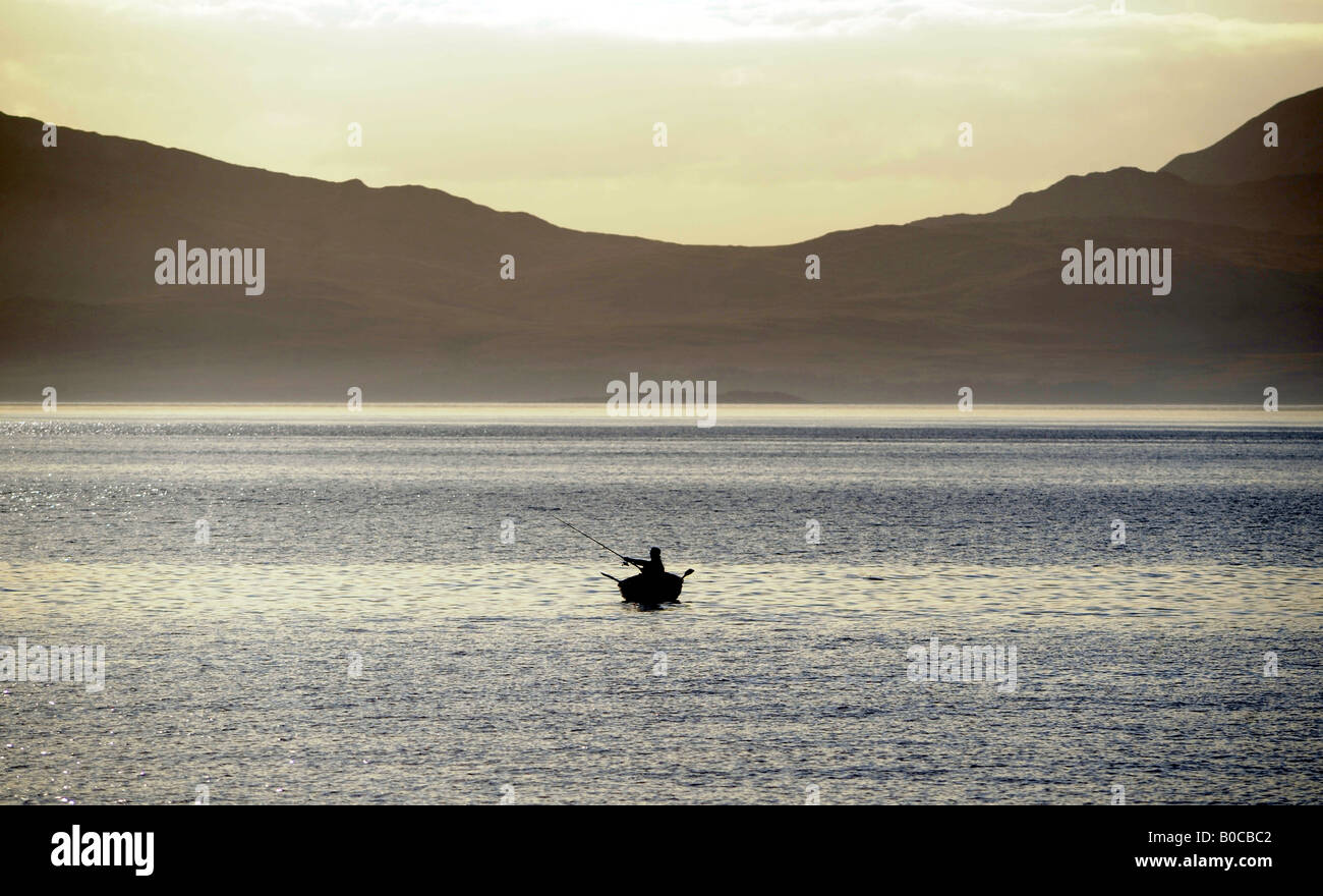 Un pescatore di pesci da una barca nelle acque al largo di Kintyre,NORD OVEST DELLA SCOZIA,guardando fuori verso l'isola di Jura. Foto Stock