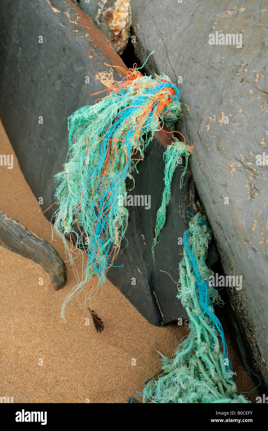 Flotsam (pezzo di rete da pesca) catturati sulle rocce, costa nord della Cornovaglia, Inghilterra Foto Stock