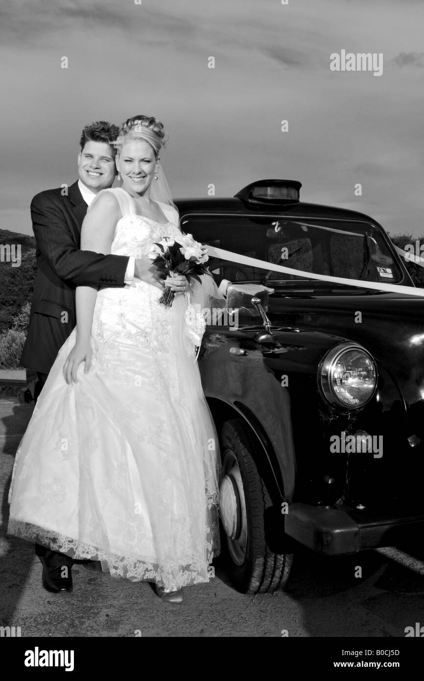 Sposa e lo sposo in piedi con le loro auto nozze kissing Foto Stock