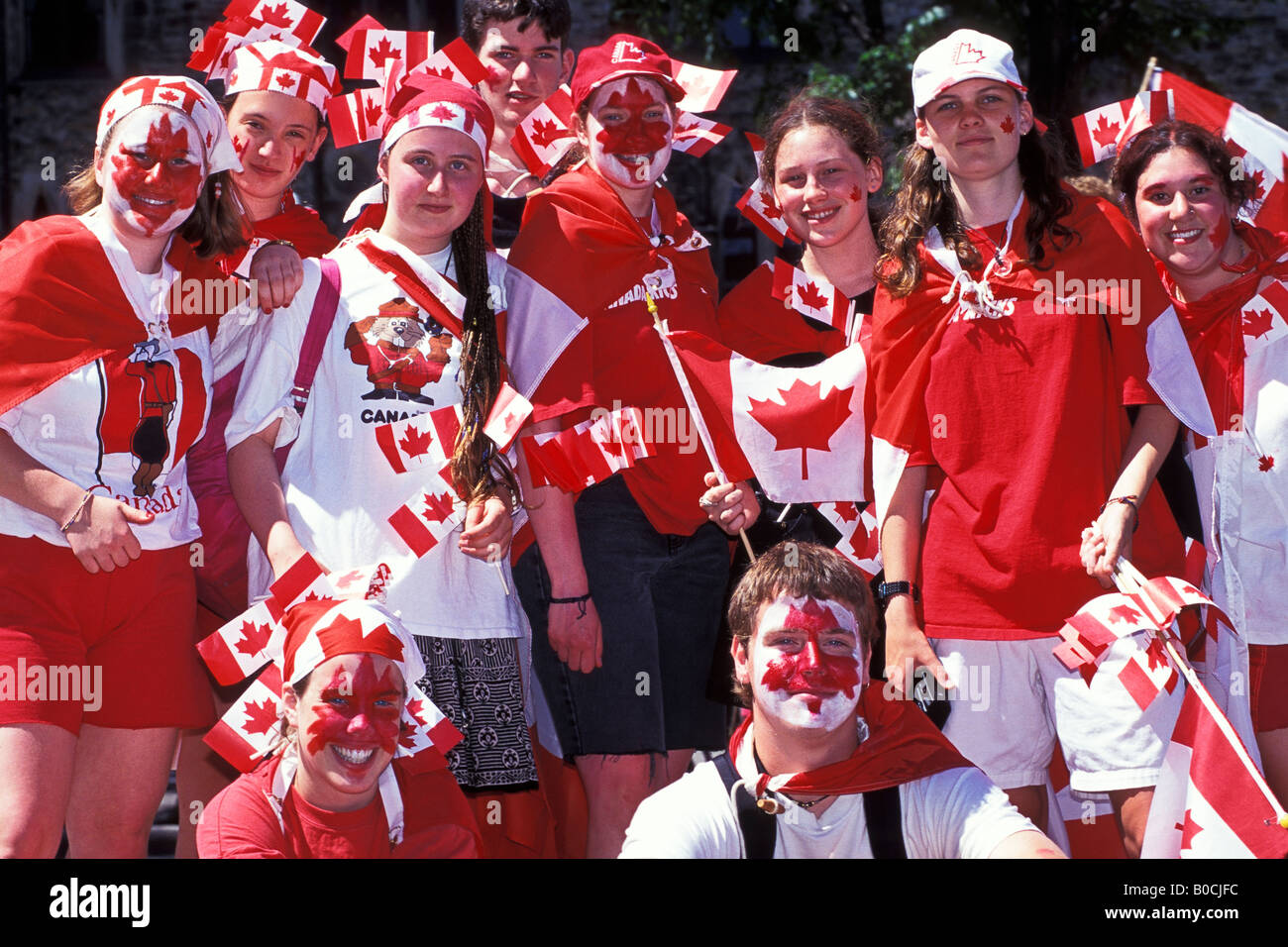 Gli adolescenti con bandiere canadesi vestita di bianco e rosso Canada giornata presso gli edifici del Parlamento sulla Collina del Parlamento Ottawa Ontario Foto Stock