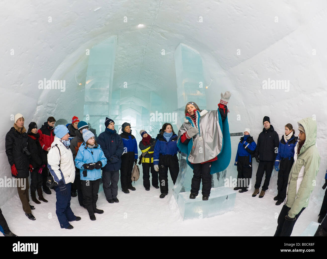 I visitatori di ascoltare la guida per un tour guidato all'interno del Jukkasjarvi icehotel nella Svezia settentrionale Foto Stock