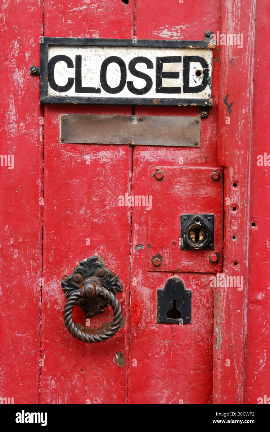 La vecchia porta su una ferramenta in Dartmouth, Devon, Regno Unito, con respingente e 'chiuso' firmare Foto Stock