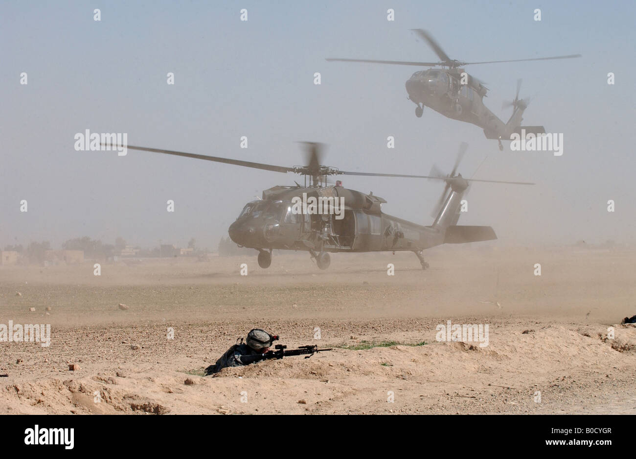 Due U S Army UH 60 Black Hawk elicotteri Blow up nubi di polvere come essi entrano in una zona di atterraggio a Samarra in Iraq Foto Stock