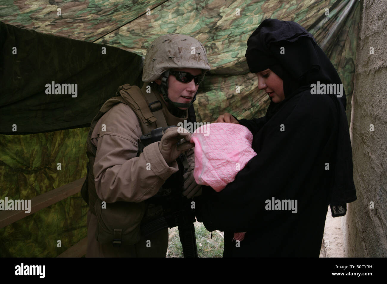 U S Marine Corps Cpl Jessica Morse guarda un donna irachena s bambino durante una cooperativa impegno medico in Abu Kalifa Iraq Foto Stock
