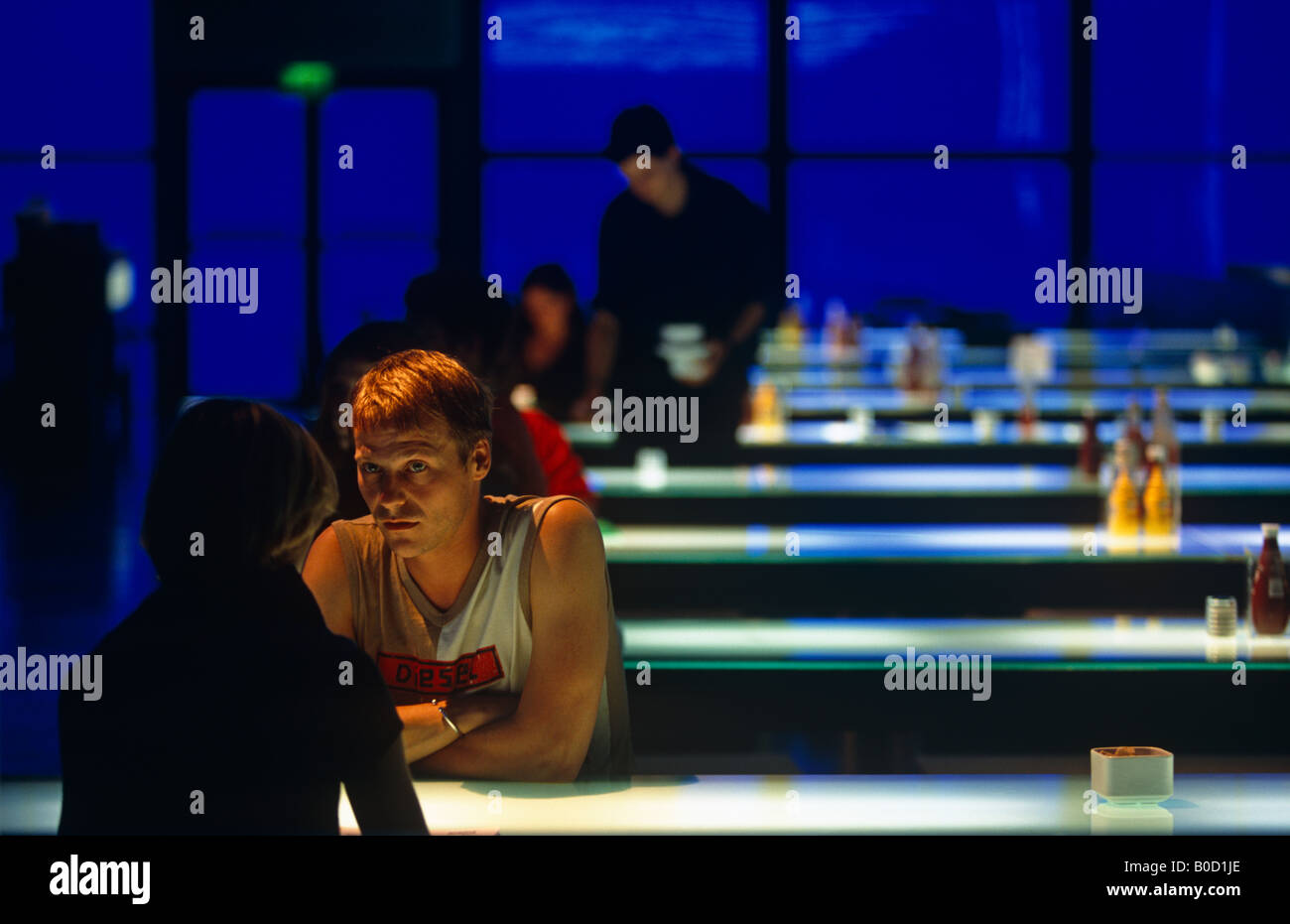 Una coppia giovane seduto su una panchina di una intensa e intima talk in London Science Museum di Deep Blue Cafe Foto Stock