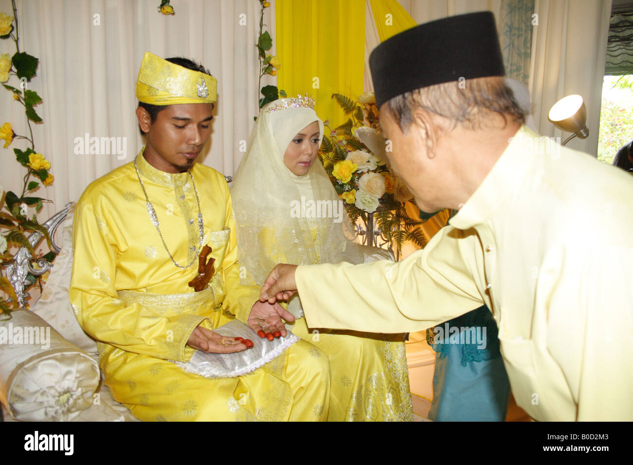 Il malese sposo e sposa nella cerimonia di nozze tradizionale Foto Stock