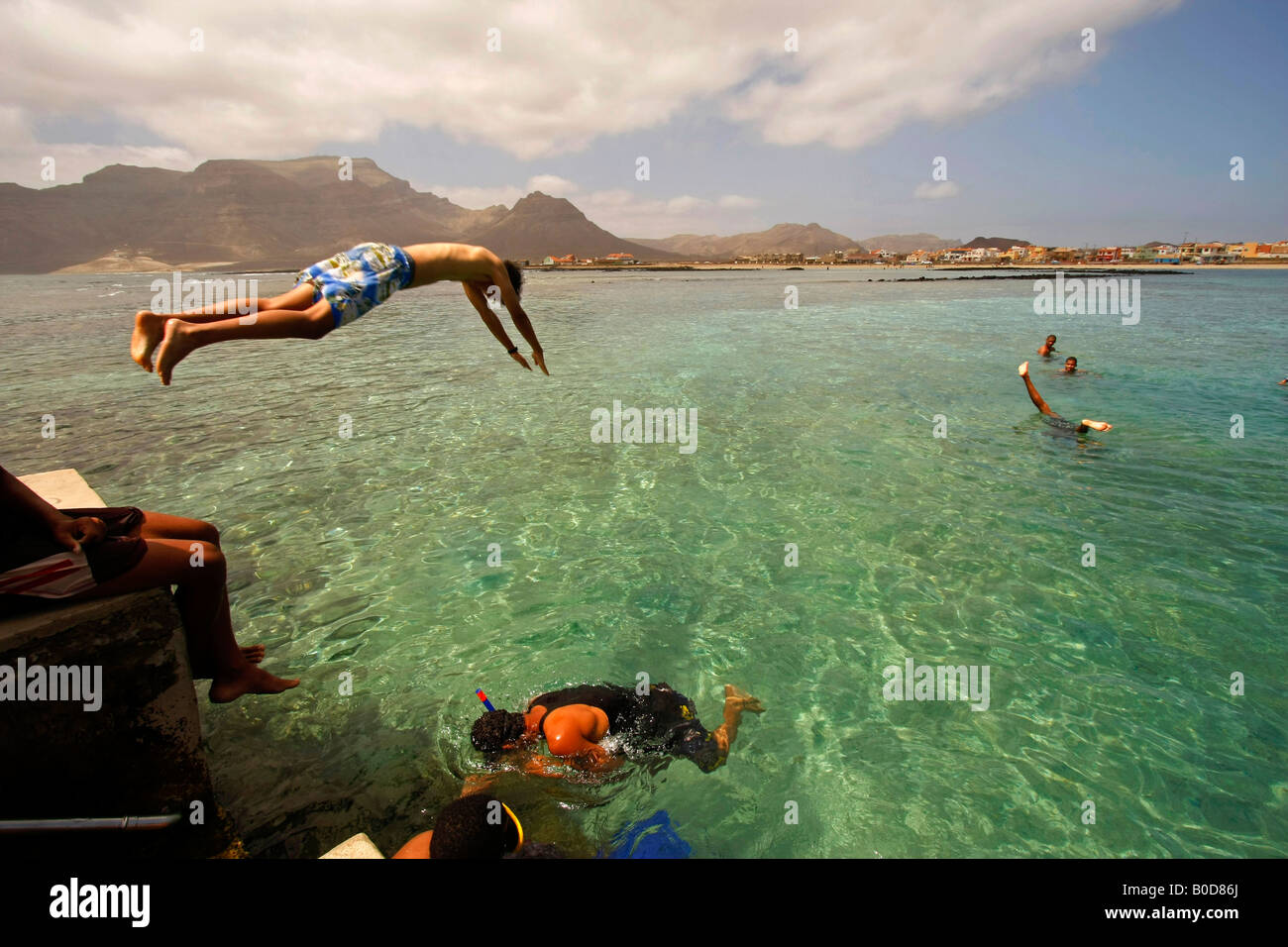 La gioventù saltare in acqua chiara presso la spiaggia di Baia das Gatas sull'isola di Sao Vicente Capo Verde Africa Foto Stock