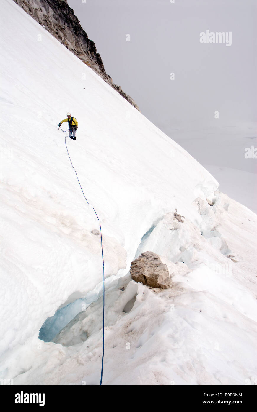 L'alpinista attraversando il bergschrund sotto il troll, piccola Svizzera, Pika ghiacciaio, Alaska Foto Stock