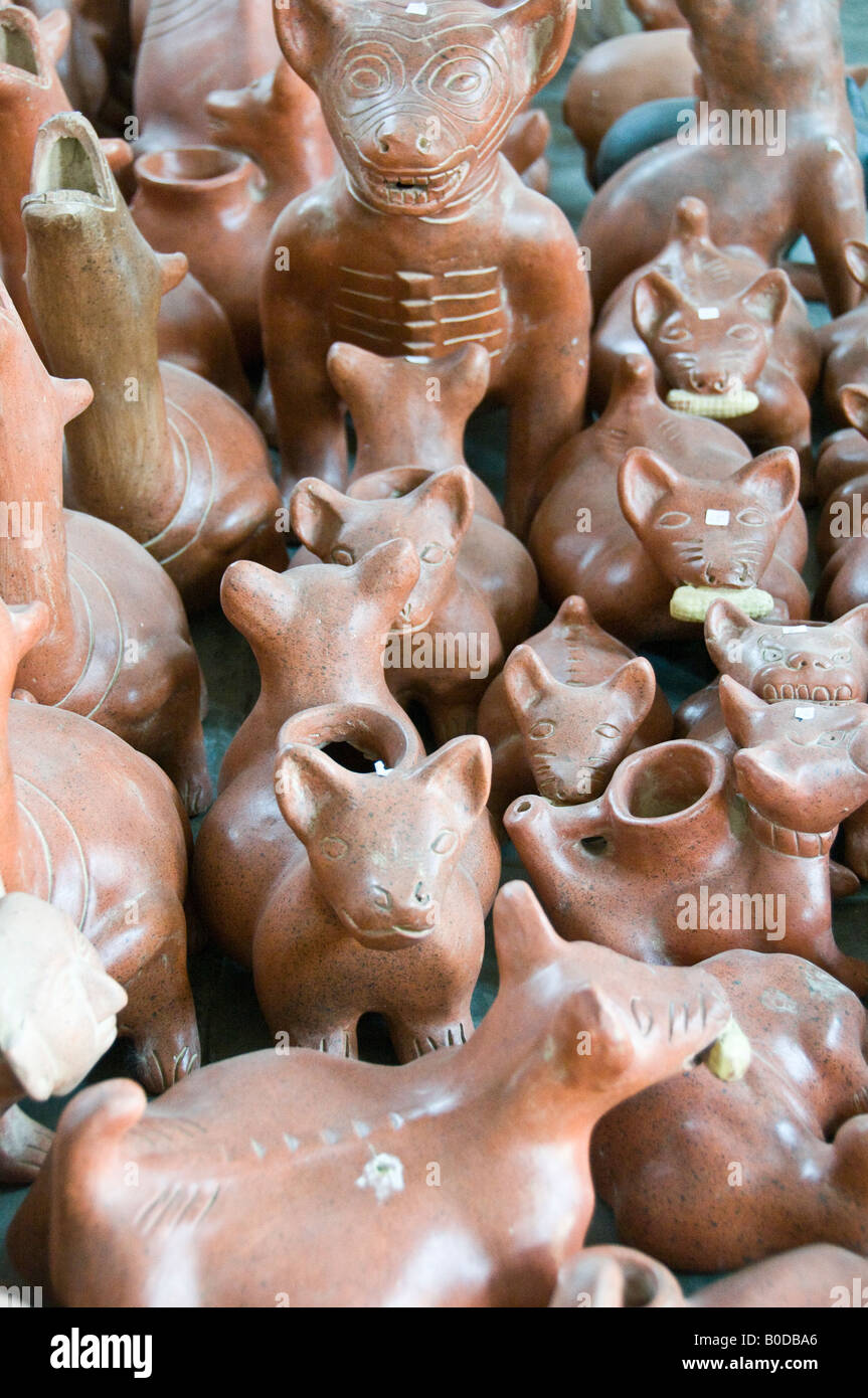 Stile azteco souvenir cani - o forse il coyote in vendita in un mercato di strada in Cholula, Messico. Alcuni hanno il granturco dolce nelle loro bocche. Alcuni forse lampade a olio Foto Stock