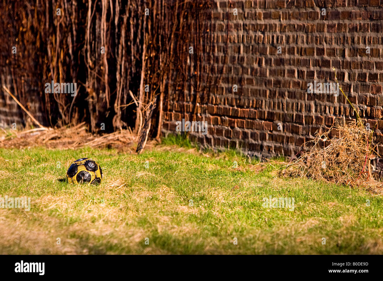 Un pallone da calcio riposa in un piccolo cortile in città. Foto Stock