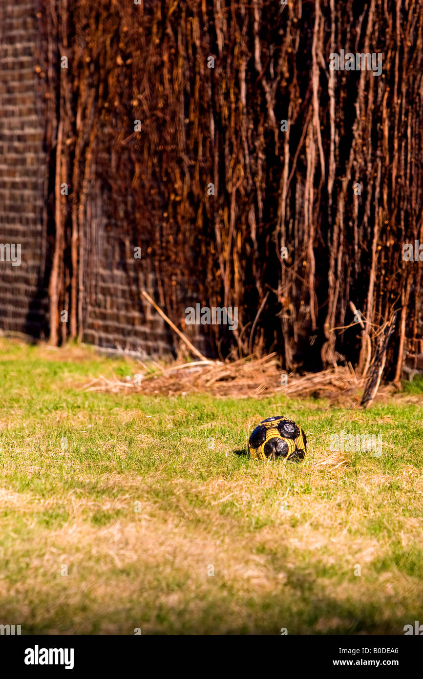Un pallone da calcio riposa in un piccolo cortile in città. Foto Stock