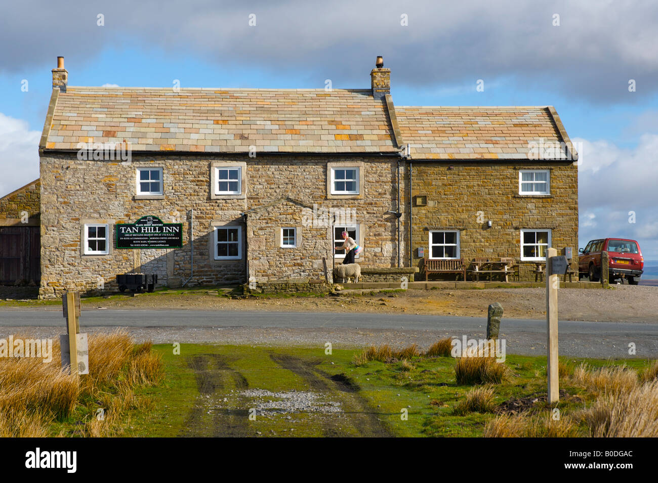 Donna che cammina in lonely Tan Hill Inn: a 1.732 metri sopra il livello del mare, il pub più alto in Gran Bretagna. Swaledale, Yorkshire Dales Na Foto Stock Donna che cammina in lonely Tan Hill Inn: a 1.732 metri sopra il livello del mare, il pub più alto in Gran Bretagna. Swaledale, Yorkshire Dales Na Foto Stock