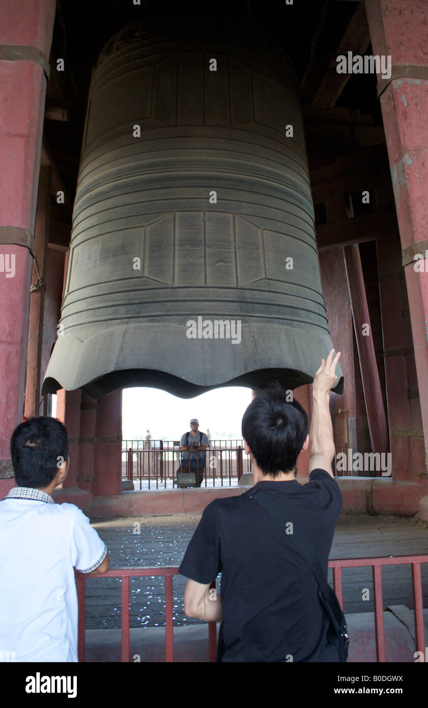 I turisti cinesi gettando delle monete in bronzo la campana della torre campanaria Pechino CINA Foto Stock