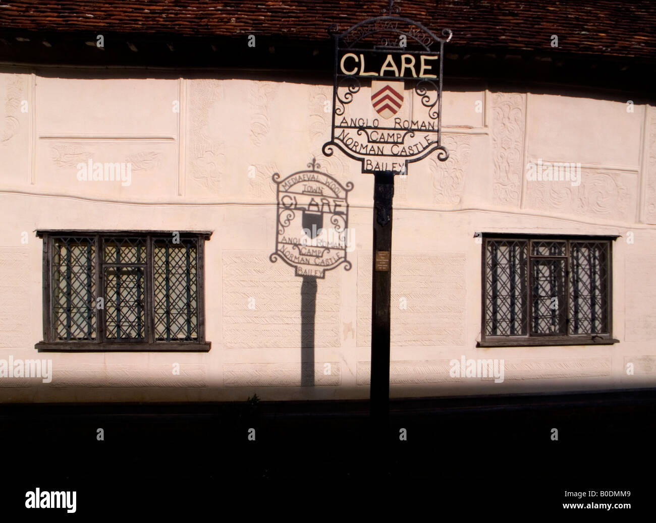 La città di chiara nel Suffolk, Inghilterra Gran Bretagna firmano ombra sul muro del vecchio edificio PARGETTED IN CLARE R Foto Stock