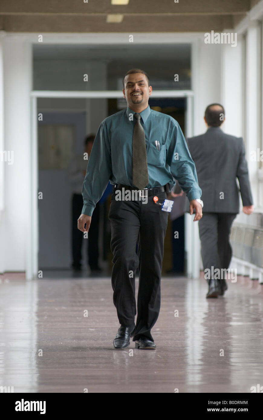 Medico passeggiate lungo un corridoio in un ospedale Foto Stock