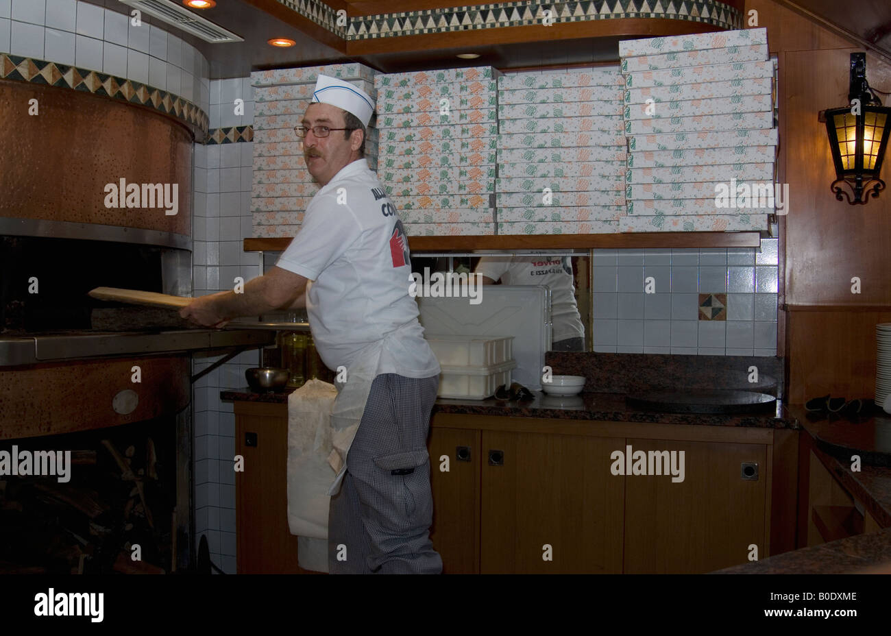 Pizza Chef mettendo i log in pizza al forno a legna forno Foto Stock Pizza Chef mettendo i log in pizza al forno a legna forno Foto Stock