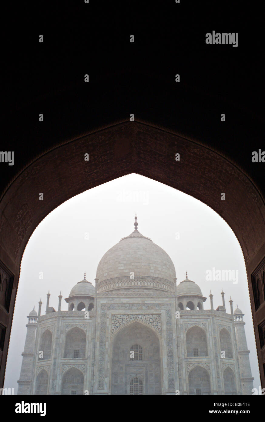 INDIA AGRA monumento del Taj Mahal si vede attraverso un arco di mattina nebbia di sunrise Foto Stock